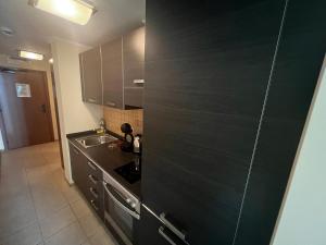 a kitchen with a black door and a sink at Апартамент Сънсет Ризорт in Pomorie