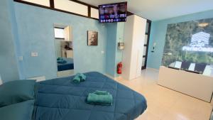 a bedroom with a blue bed and a tv at Suite Perlacasa in Vigevano