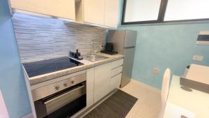 a small kitchen with a sink and a refrigerator at Suite Perlacasa in Vigevano