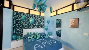 a room with a bed with green balloons on the wall at Suite Perlacasa in Vigevano +16 photos