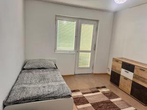 a bedroom with a bed and a dresser and a window at E&H Appartements in Bregenz