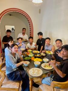 a group of people sitting around a table eating food at Yaro Backpackers Hostel in Guwahati