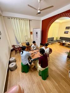 a group of people sitting around a table playing a game at Yaro Backpackers Hostel in Guwahati