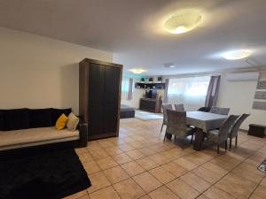 a living room with a couch and a table and chairs at Holiday Apartman in Kecskemét