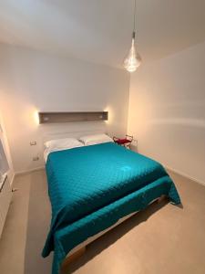 a bedroom with a bed with a green blanket at Da Nella 1 in Ancona