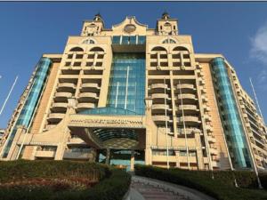 a large building with a clock on top of it at Апартамент Сънсет Ризорт in Pomorie
