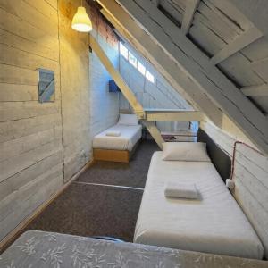 a attic room with two beds and a staircase at Ambra Apartaments Palanga in Palanga