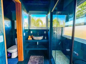 a blue bathroom with a sink and a toilet at Stupa Eco Vila in Barra de Ibiraquera +54 photos