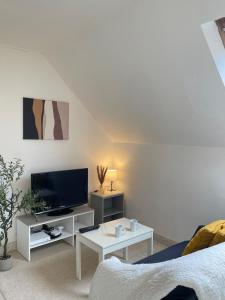 a white living room with a tv and a couch at L'écrin de marbre, hyper centre, PARKING in Quimper