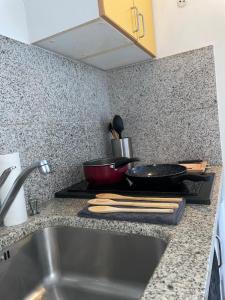 a kitchen counter with a stove with a pan on it at L'écrin de marbre, hyper centre, PARKING in Quimper +19 photos