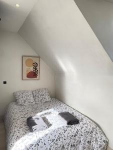 a bedroom with a bed with a black and white comforter at L'écrin de marbre, hyper centre, PARKING in Quimper