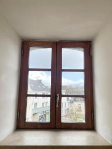 a large wooden door with three windows in a room at L'écrin de marbre, hyper centre, PARKING in Quimper