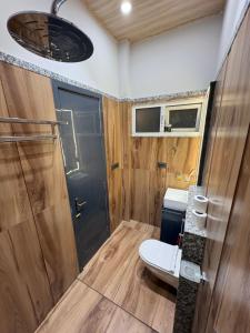 a small bathroom with a toilet and a shower at Jhigu in Siliguri +47 photos