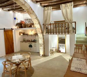 a living room with a table and a kitchen at Floura's Kamariko - Authentic Rhodian Village House in Archangelos