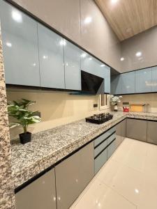 a kitchen with white cabinets and a potted plant at Jhigu in Siliguri