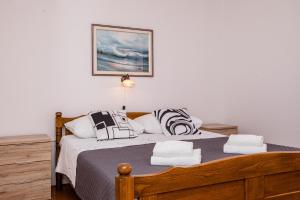 a bedroom with a bed with black and white pillows at Apartments Fabijanić in Rab