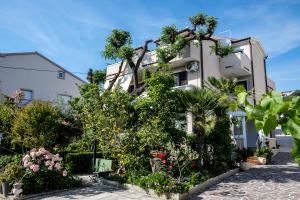 a building with plants and flowers in front of it at Apartments Fabijanić in Rab