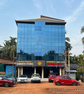 a tall building with cars parked in front of it at Shridevi Residency in Honāvar