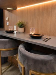 a table with two chairs and two glasses on top at PierMauá-Rooftop, Vista, Piscina, Sauna, VLT & Maracanã in Rio de Janeiro +53 photos