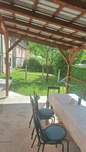 a patio with a table and chairs under a pergola at Apartman Vuković in Foča