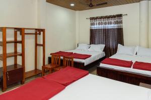 a room with two beds with red sheets at Shridevi Residency in Honāvar