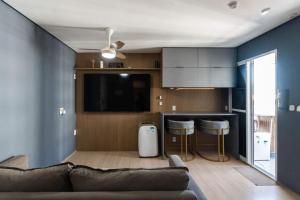a living room with a couch and a kitchen at PierMauá-Rooftop, Vista, Piscina, Sauna, VLT & Maracanã in Rio de Janeiro