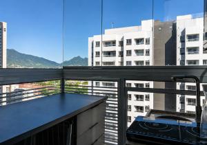 a balcony with a kitchen with a view of a building at PierMauá-Rooftop, Vista, Piscina, Sauna, VLT & Maracanã in Rio de Janeiro