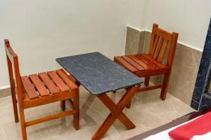 two chairs and a table and a table and a table and chair at Shridevi Residency in Honāvar