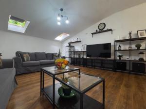 a living room with a couch and a tv at Dare apartments 3 in Giurgiu