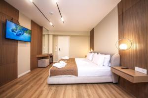 a hotel room with a bed and a flat screen tv at Hotel Panorama Ksamil in Ksamil