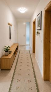 a hallway with a table and a rug on the floor at Sarajevo Apartment in Sarajevo