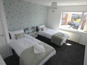 a bedroom with two beds and a window at Contractors , holiday house, free parking , sleeps 5 in Knowsley