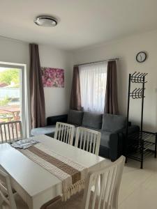 a living room with a couch and a table and chairs at Murvafürt Vendégház in Cserkeszőlő