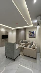 a living room with two couches and a tv at سمسمه للشقق المخدومه in Quai