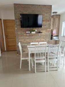 a dining room with a white table and chairs at Murvafürt Vendégház in Cserkeszőlő