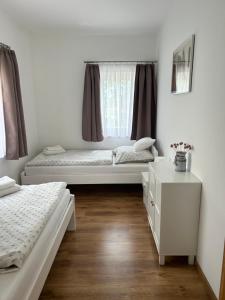 a bedroom with two beds and a window at Murvafürt Vendégház in Cserkeszőlő