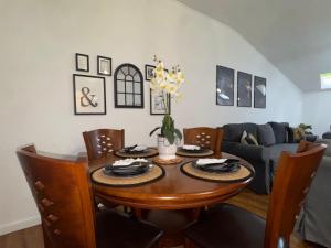 a dining room table with chairs and a couch at Dare apartments 3 in Giurgiu
