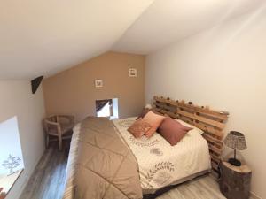 a bedroom with a bed with a wooden headboard at Gîte la maison de Mika in Saint-Floret