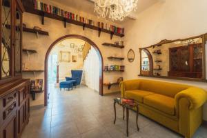a living room with a yellow couch and an archway at 3BR Townhouse with Private Rooftop in Bormla in Taʼ Penza