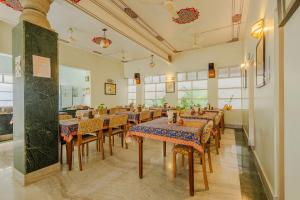 a restaurant with tables and chairs in a room at Tara Niwas in Jaipur