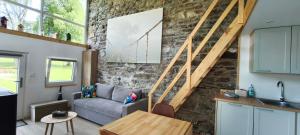 a living room with a couch and a stone wall at En aparté in Vielsalm +8 photos