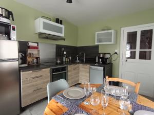 a kitchen with a table with wine glasses on it at Gîte la maison de Mika in Saint-Floret