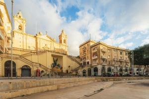 a large building with a clock tower in a street at 3BR Townhouse with Private Rooftop in Bormla in Taʼ Penza