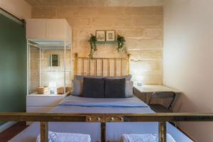 a small bedroom with a bed and a desk at 3BR Townhouse with Private Rooftop in Bormla in Taʼ Penza