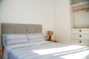a bedroom with a bed with blue sheets and a dresser at Casa Ines in Playa Honda