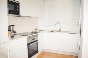 a white kitchen with white cabinets and a sink at Casa Ines in Playa Honda +7 photos