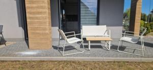 a group of chairs and a table in front of a building at Apartament MyMoment in Tupadła
