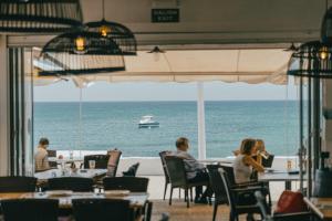 a group of people sitting at a restaurant looking out at the ocean at Casa Ines in Playa Honda