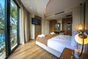a bedroom with a large bed and a large window at Hotel Panorama Ksamil in Ksamil