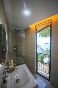a bathroom with a white sink and a window at Hotel Panorama Ksamil in Ksamil +57 photos